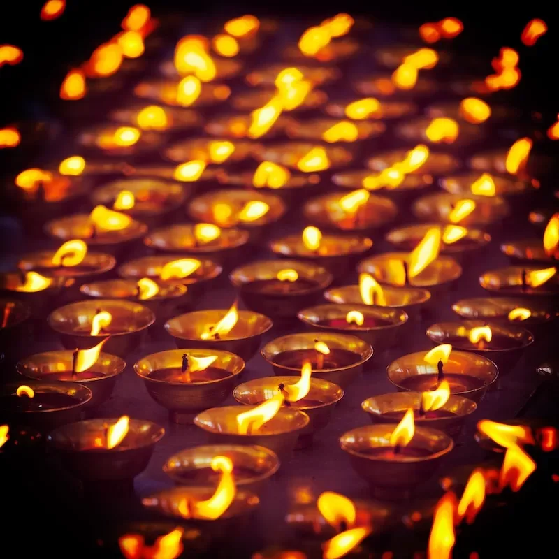 Vintage retro effect filtered hipster style travel image of burning candles in Buddhist temple. Tsuglagkhang complex, McLeod Ganj, Himachal Pradesh, India