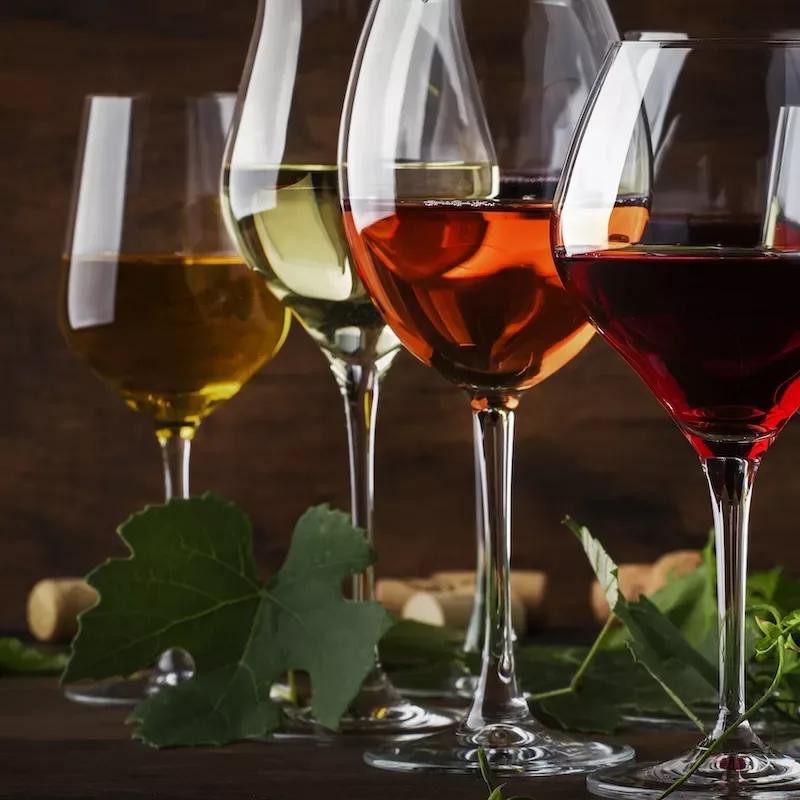 Wine set. Red, white and rose wine in assortment in wineglasses. Wine tasting, vintage wooden background, selective focus, copy space